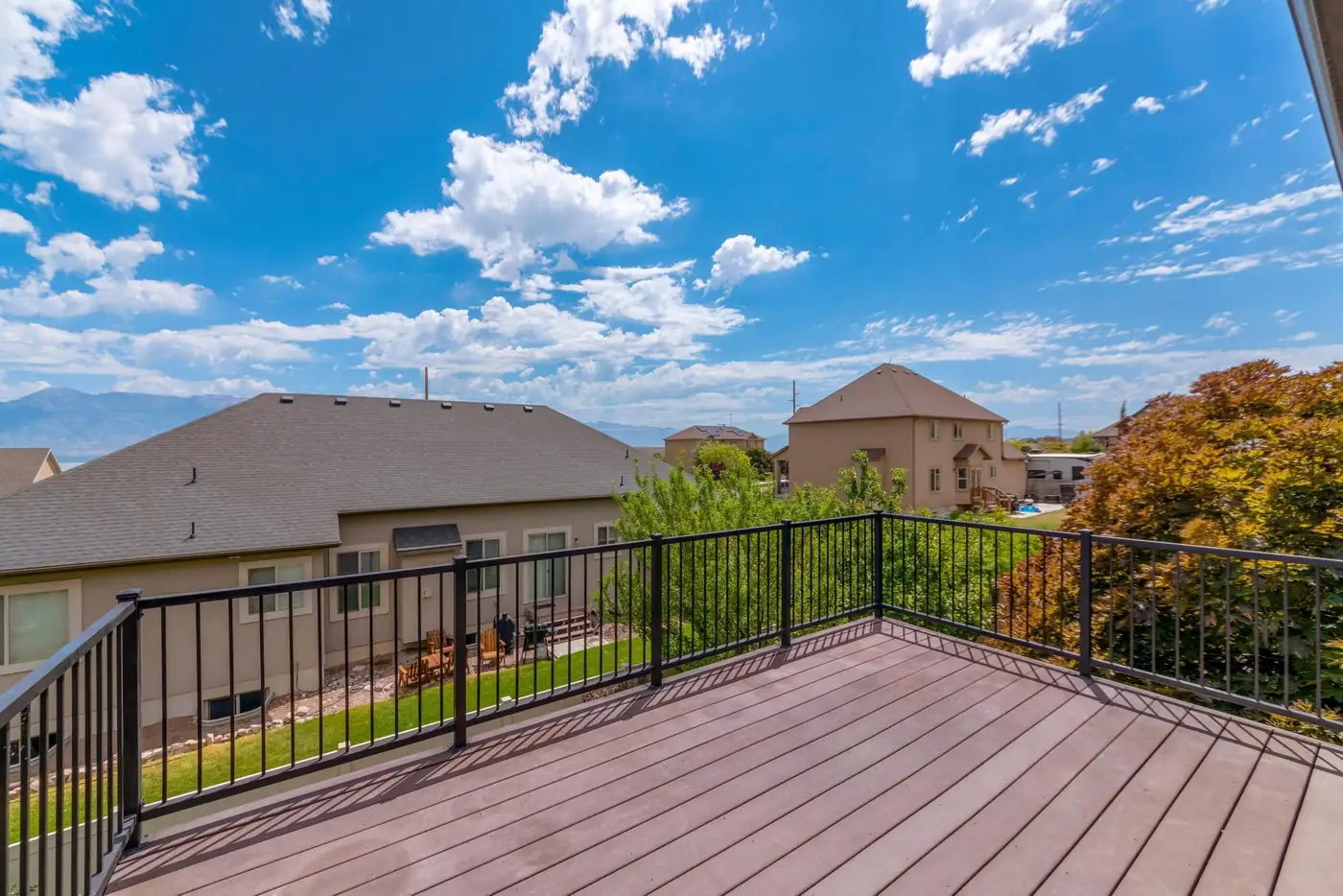 Composite deck with black aluminum balusters overlooking a fenced backyard