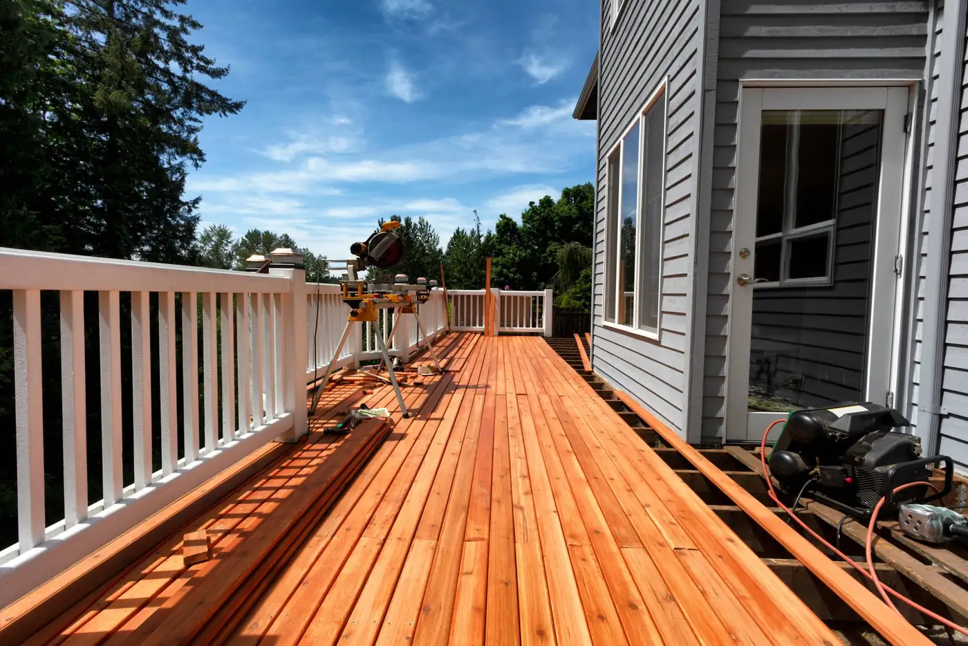 Deck builder's miter saw on fresh cedar decking during installation