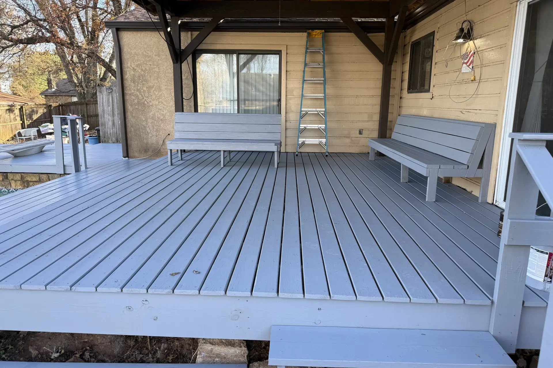 Covered porch with gray decking and a timber roof structure