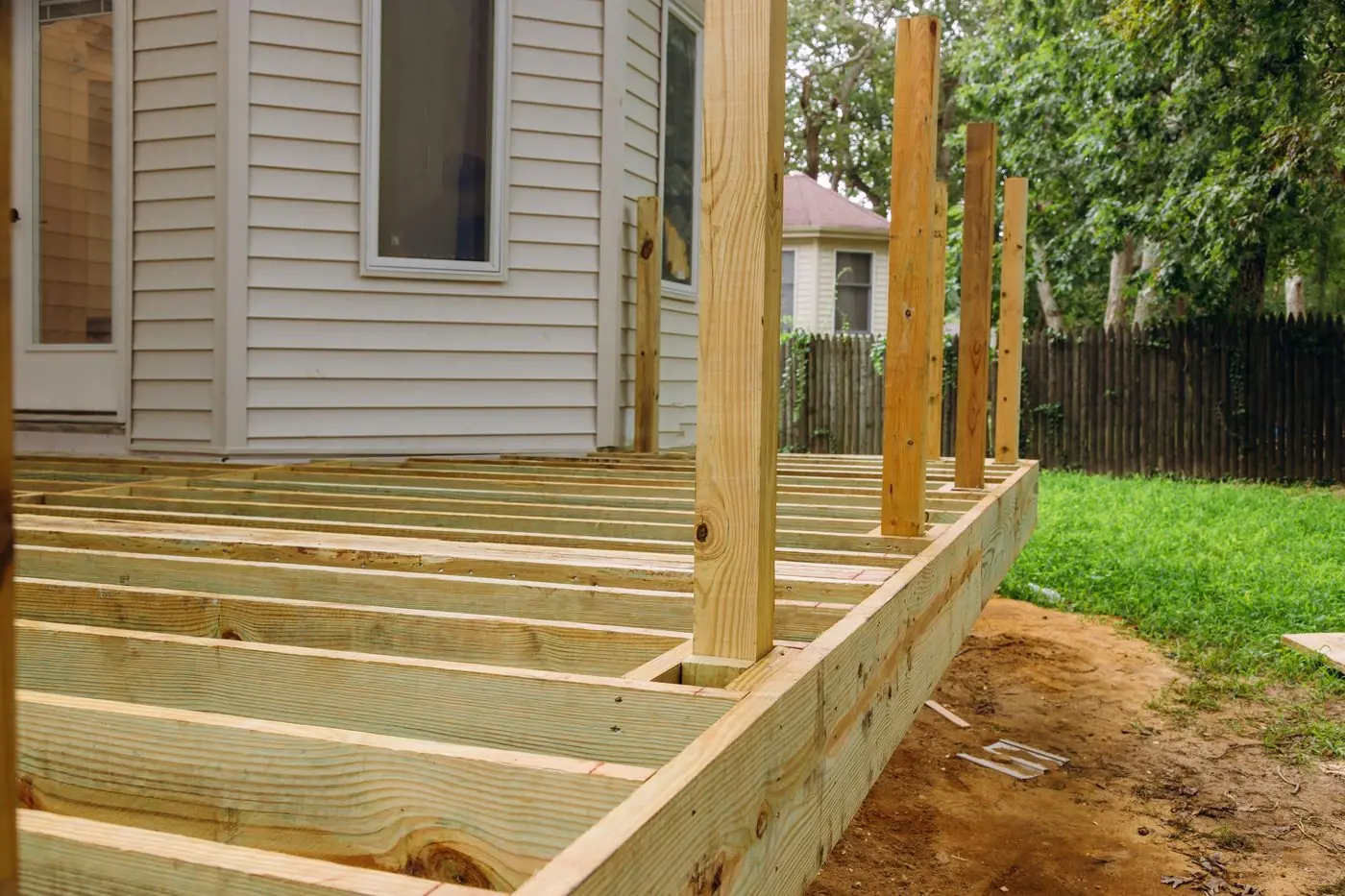Fresh pressure-treated joists and posts framed up for a deck replacement